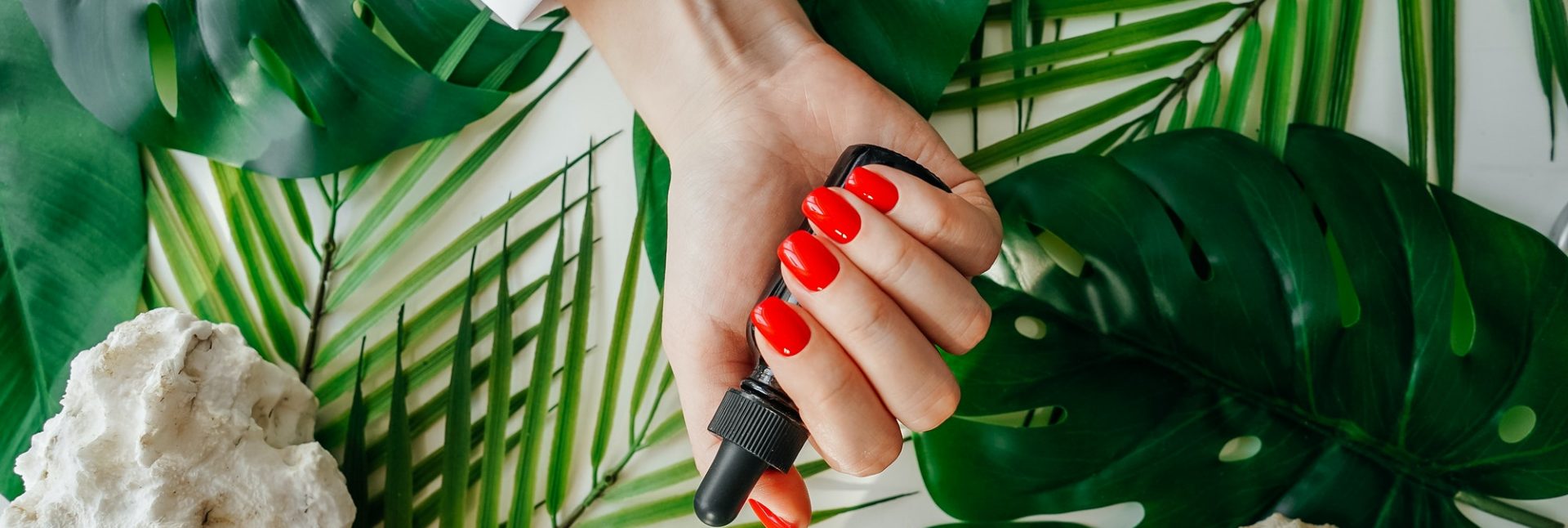 Manicured woman's nails with red nail polish.
